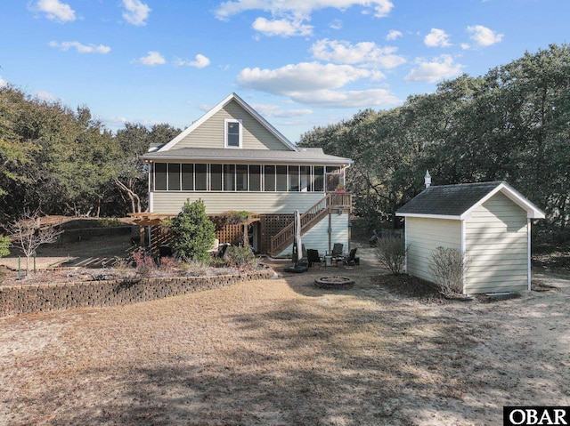 view of front facade with a fire pit, stairway, and a sunroom