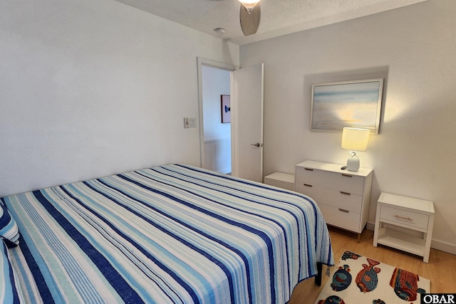 bedroom with light wood-style flooring and a textured ceiling