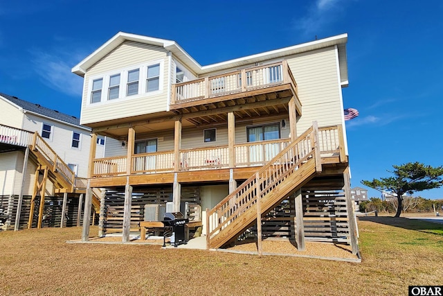 back of property featuring stairs, a yard, a deck, and a patio area