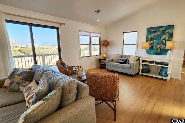 living area with lofted ceiling, wood finished floors, and visible vents