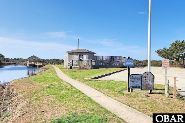 surrounding community featuring a gazebo, a lawn, and a water view