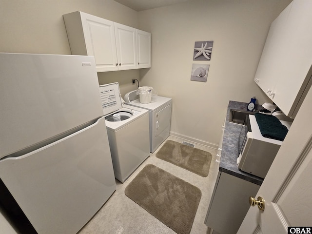 laundry room with cabinet space, baseboards, and separate washer and dryer