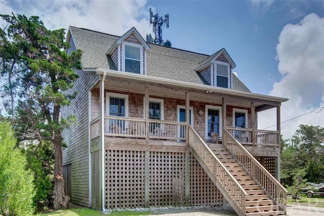 view of front of house with a porch, stairs, and roof with shingles