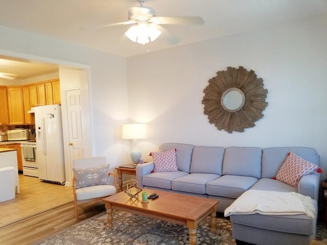 living area featuring a ceiling fan and light wood finished floors