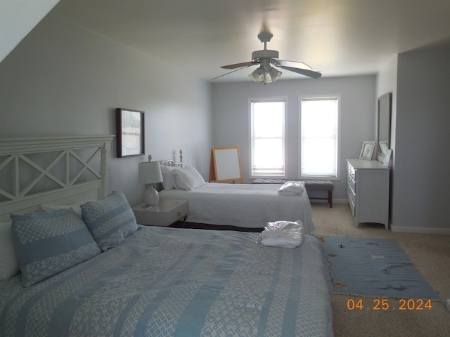 bedroom with baseboards, a ceiling fan, and light carpet