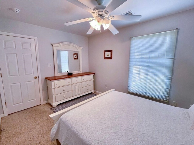 bedroom with visible vents, ceiling fan, and light colored carpet