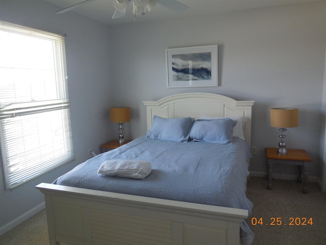 bedroom with a ceiling fan, light colored carpet, and baseboards