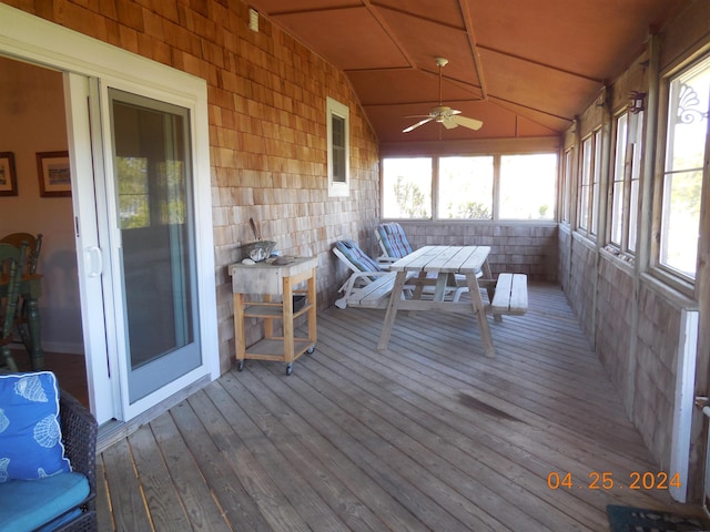 sunroom with a ceiling fan and outdoor dining space