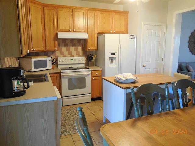 kitchen featuring under cabinet range hood, light tile patterned flooring, tasteful backsplash, a ceiling fan, and white appliances