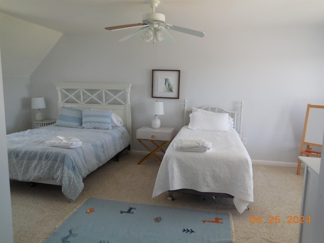 carpeted bedroom featuring ceiling fan, vaulted ceiling, and baseboards