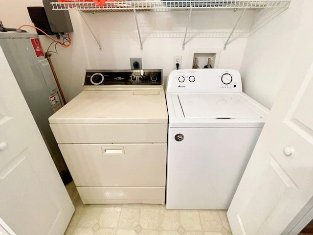 washroom featuring light tile patterned floors, washing machine and clothes dryer, and laundry area