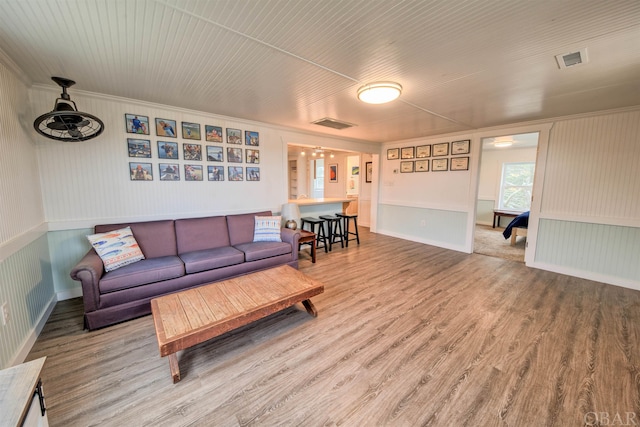 living area featuring visible vents and wood finished floors