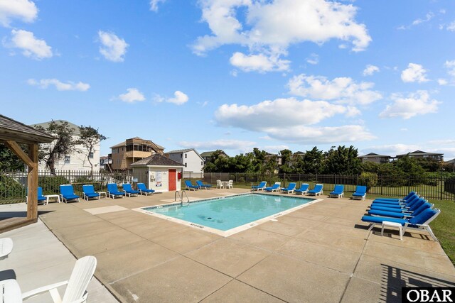 pool with a patio area and fence