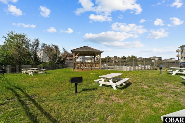 view of community with a lawn, a gazebo, and fence