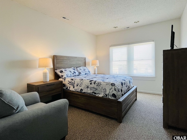 carpeted bedroom featuring a textured ceiling, visible vents, and baseboards