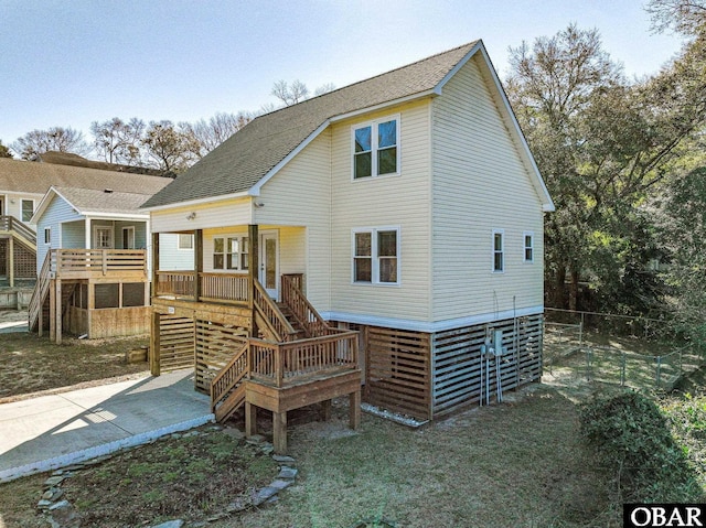 back of property with covered porch, stairs, and roof with shingles