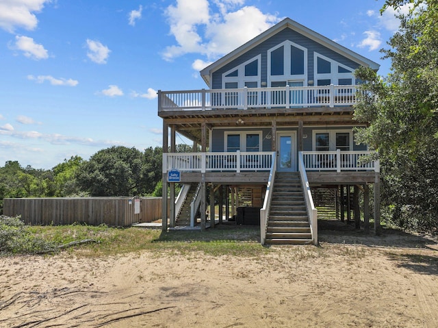 view of front of property with stairs, a porch, and fence