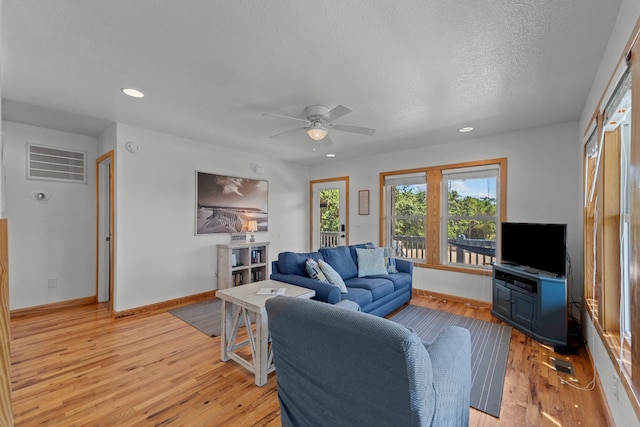 living area with a textured ceiling, recessed lighting, visible vents, baseboards, and light wood-style floors