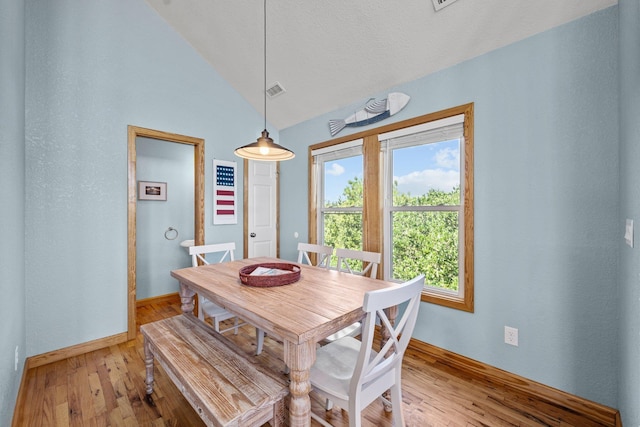 dining area featuring vaulted ceiling, visible vents, light wood-style flooring, and baseboards