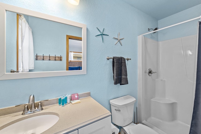 full bath featuring toilet, a shower stall, and vanity