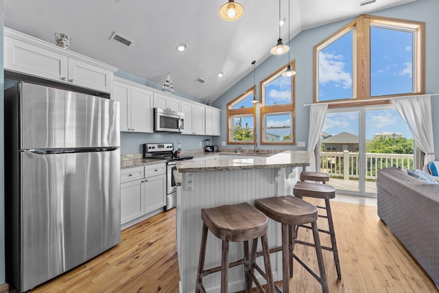 kitchen with decorative light fixtures, visible vents, appliances with stainless steel finishes, white cabinetry, and light stone countertops