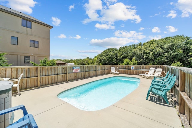 pool featuring a fenced backyard and a patio