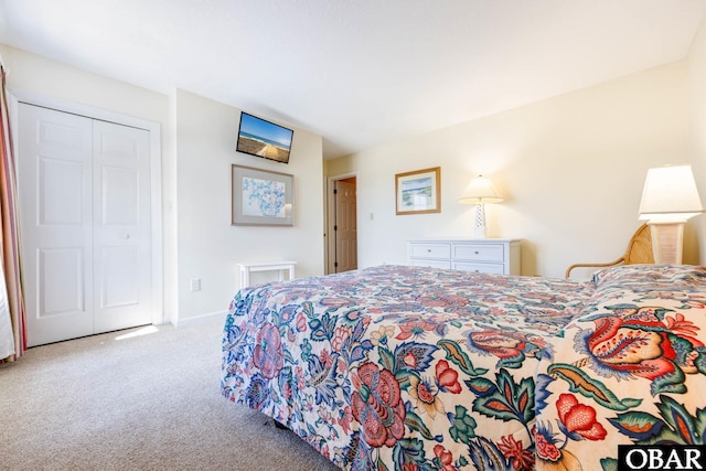 bedroom featuring light carpet, baseboards, and a closet