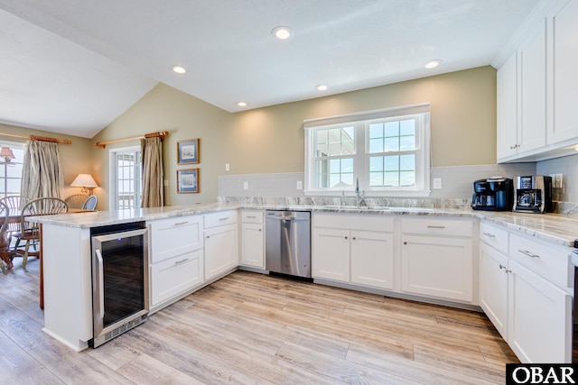 kitchen featuring wine cooler, a peninsula, a sink, white cabinets, and stainless steel dishwasher