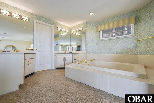 bathroom featuring a garden tub, vanity, and wallpapered walls