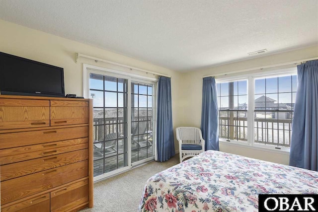 bedroom with access to exterior, visible vents, light carpet, and a textured ceiling