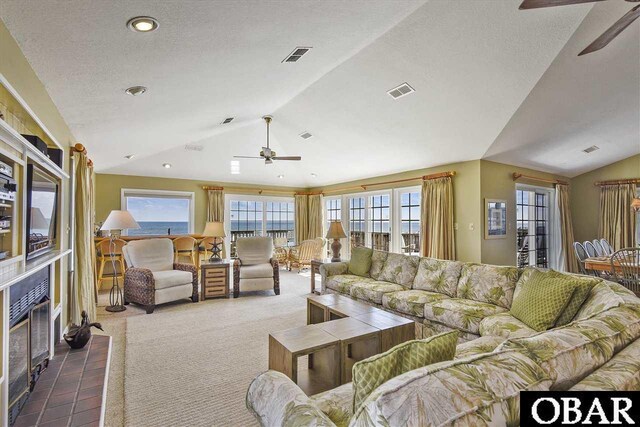 carpeted living area featuring plenty of natural light, visible vents, and vaulted ceiling