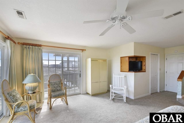 living area featuring visible vents, a textured ceiling, and carpet flooring