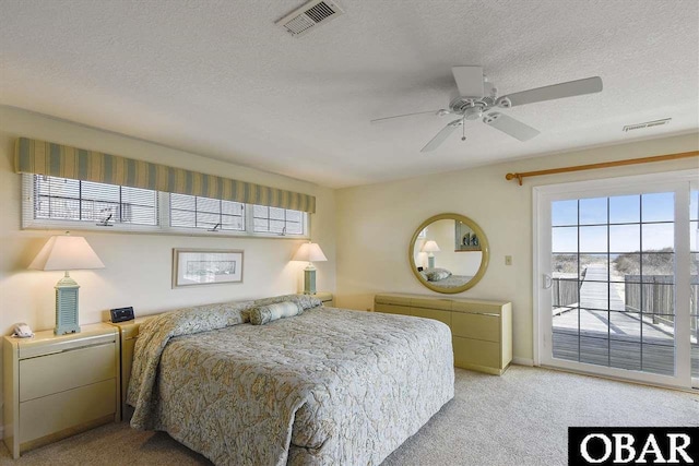 bedroom featuring access to outside, visible vents, a textured ceiling, and light colored carpet