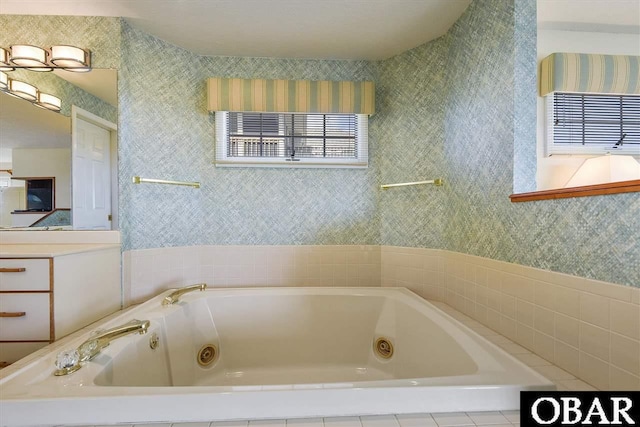 full bath with wallpapered walls, a tub with jets, and vanity