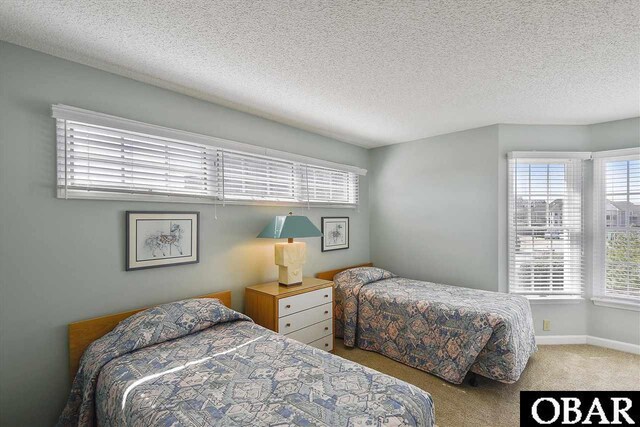 bedroom featuring a textured ceiling, carpet floors, and baseboards