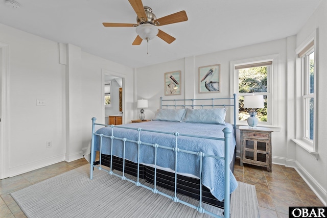 bedroom featuring a ceiling fan and baseboards