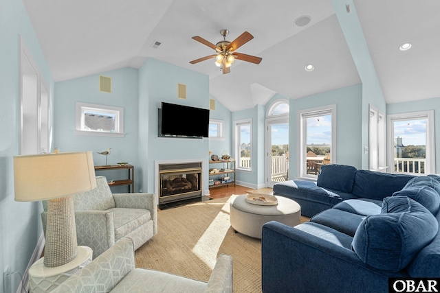 living area with visible vents, lofted ceiling, a fireplace with flush hearth, light wood-style floors, and recessed lighting