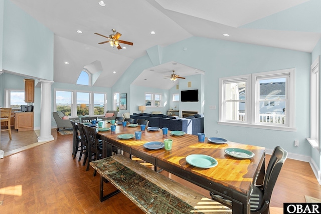 dining space featuring ceiling fan, high vaulted ceiling, recessed lighting, light wood finished floors, and ornate columns