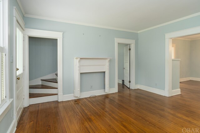 unfurnished living room with baseboards, stairway, dark wood finished floors, and crown molding