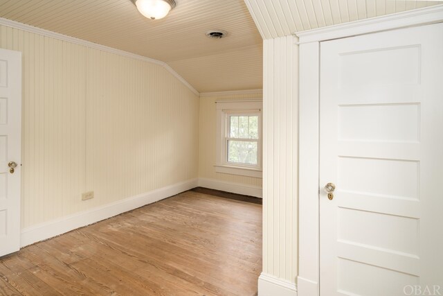 empty room with wooden ceiling, wood finished floors, visible vents, baseboards, and vaulted ceiling