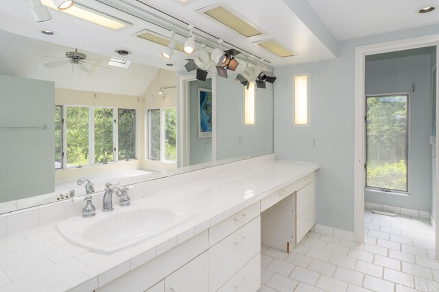 bathroom featuring vaulted ceiling, ceiling fan, vanity, and baseboards