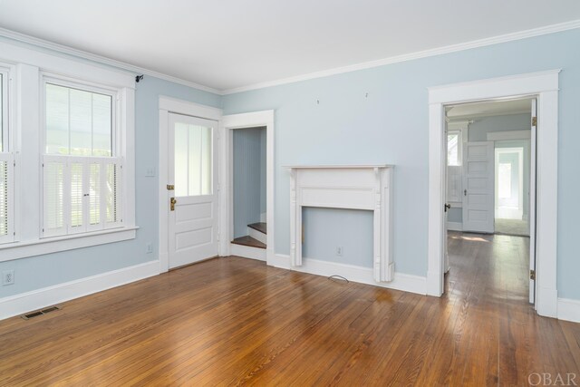 unfurnished living room featuring baseboards, dark wood-style flooring, visible vents, and crown molding