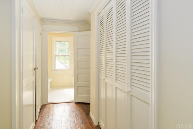 hallway with ornamental molding and dark wood-style flooring