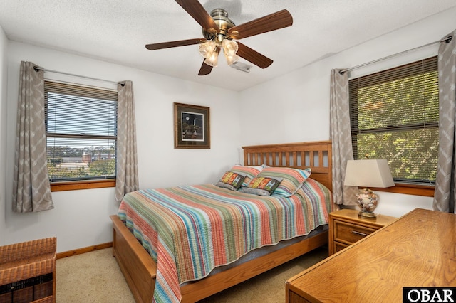 bedroom featuring ceiling fan, a textured ceiling, and baseboards