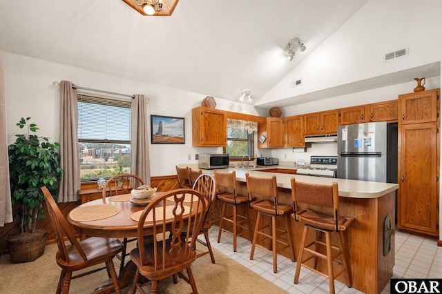 dining room featuring high vaulted ceiling and visible vents