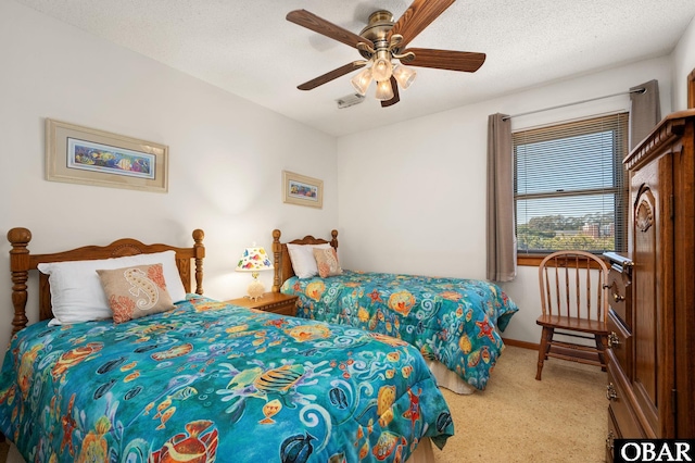 bedroom with a textured ceiling, ceiling fan, carpet floors, visible vents, and baseboards