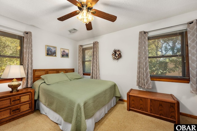 bedroom with a ceiling fan, a textured ceiling, and baseboards