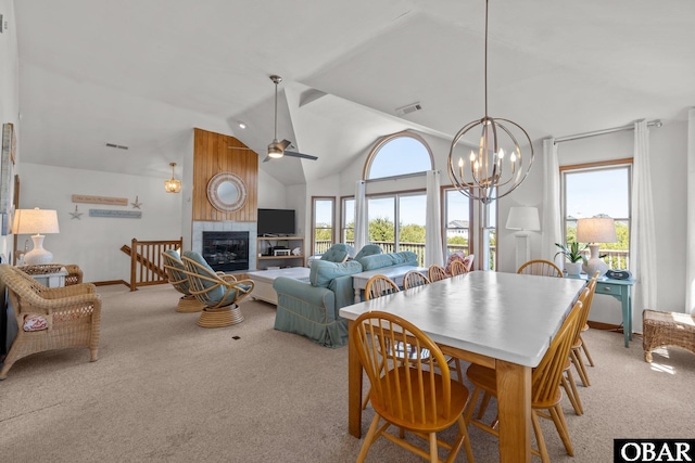 dining area featuring visible vents, baseboards, a tiled fireplace, high vaulted ceiling, and light carpet