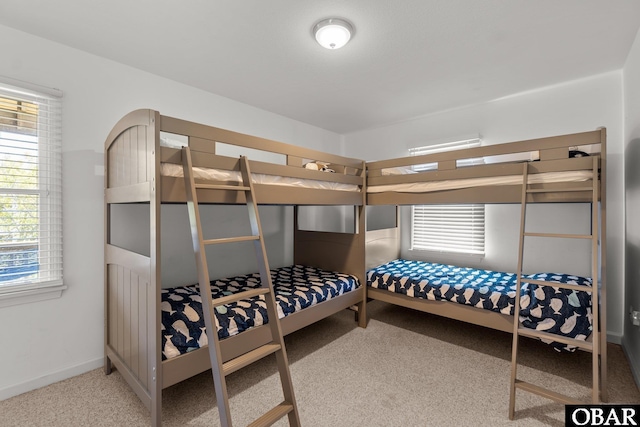 bedroom with carpet, multiple windows, and baseboards