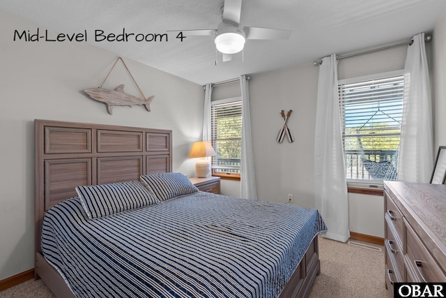 bedroom featuring light carpet, ceiling fan, and baseboards